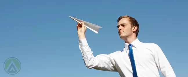 ceo outdoors about to fly paper airplane