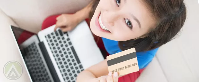 female-customer-holding-laptop-and-credit-card