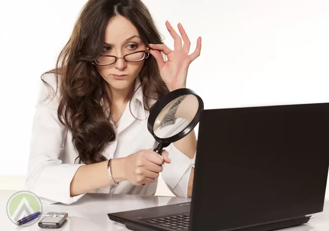 woman-in-glasses-looking-at-laptop-with-magnifying-lens