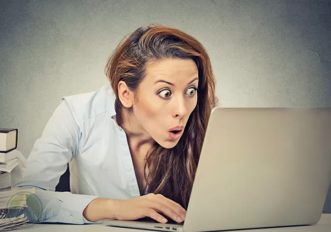 startled-female-employee-staring-at-laptop