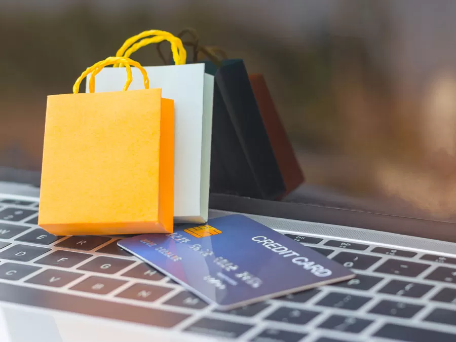 tiny shopping bags on credit card on laptop