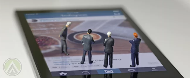 tiny-businessmen-figures-standing-on-smartphone-screen-showing-Instagram