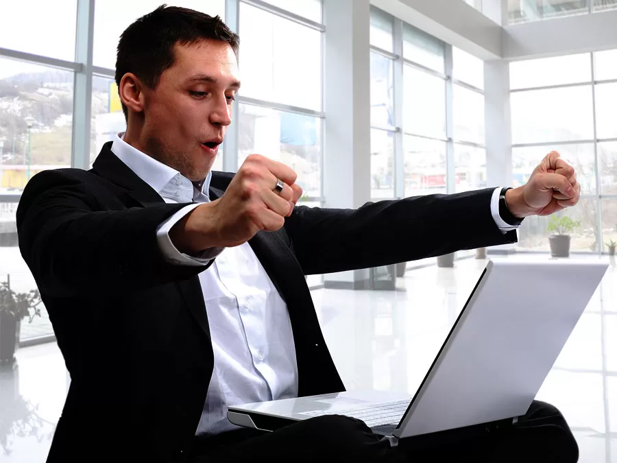 excited businessman speaking with outsourcing live chat on laptop 