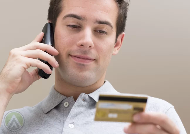 man-in-phonecall-while-looking-at-credit-card