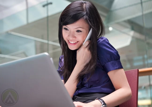 female-executive-in-phone-call-using-laptop