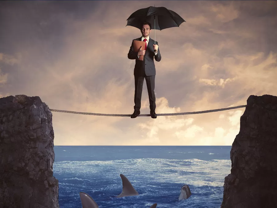 social media marketing manager holding umbrella balancing on tight ropa over shark-infested ocean