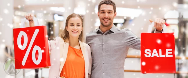 couple-in-a-holiday-sale-holding-red-shopping-bags