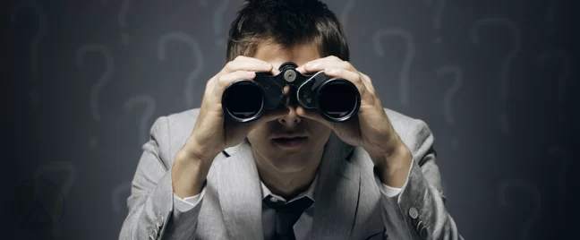 businessman-looking-through-binoculars-surrounded-by-question-marks