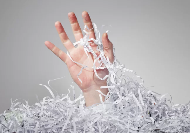 man-drowning-in-shredded-paper