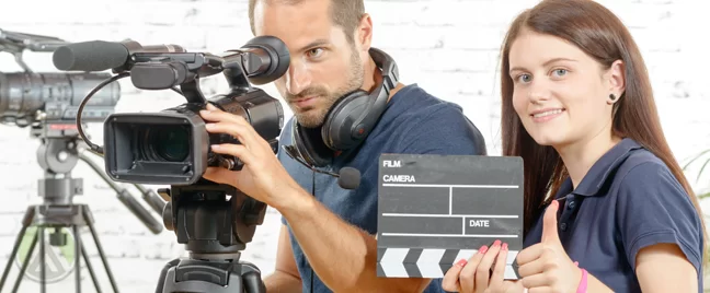 director-with-video-camera-assistant-holding-clapper