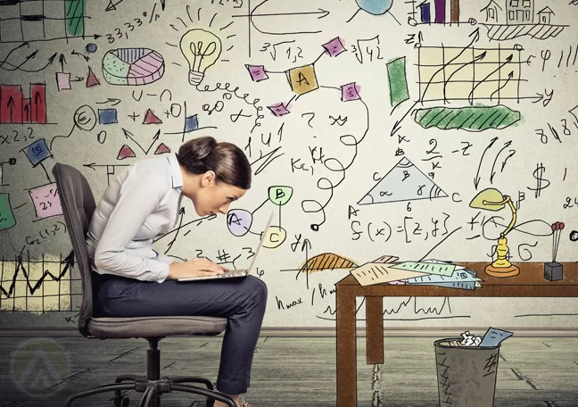 woman-using-laptop-by-office-table-surrounded-by-charts-graphs-firgures