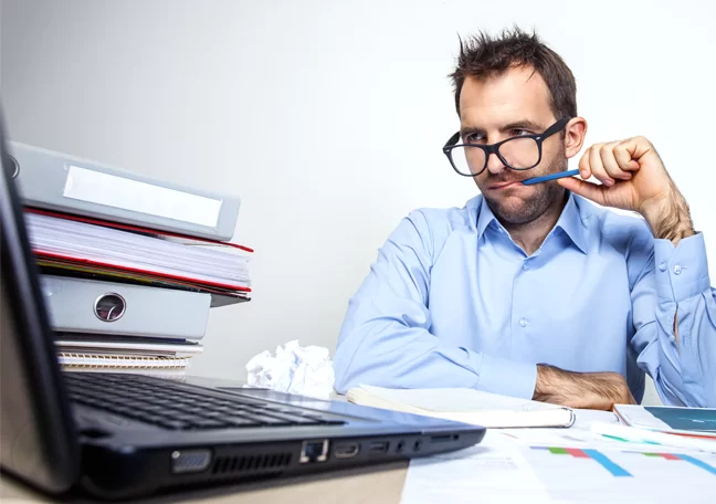 employee-in-glasses-biting-pen-staring-at-laptop