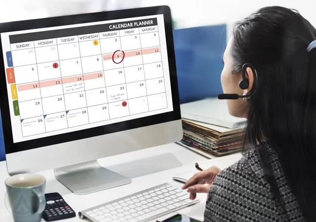 femalecall-center-agent-viewing-calendar-on-computer