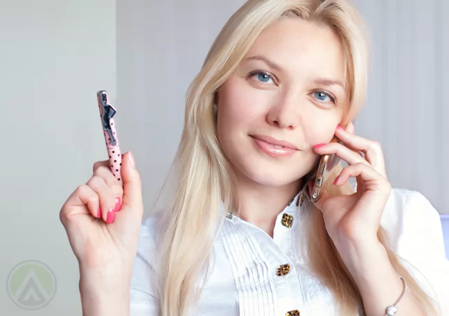 blond-female-on-phone-raising-pen