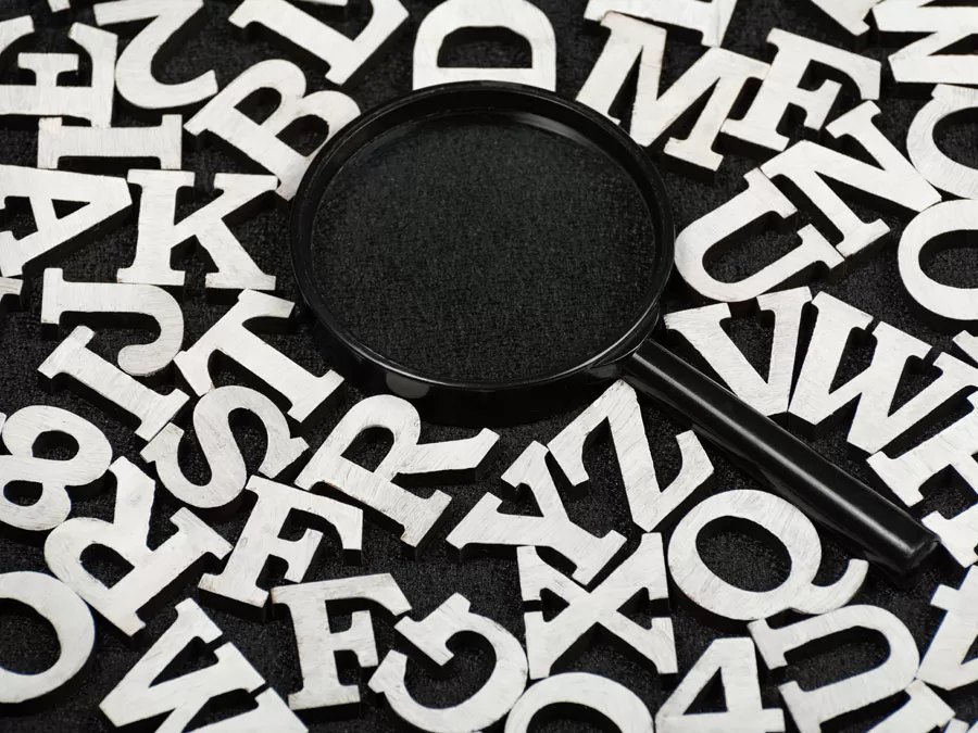 white letters around black magnifying lens