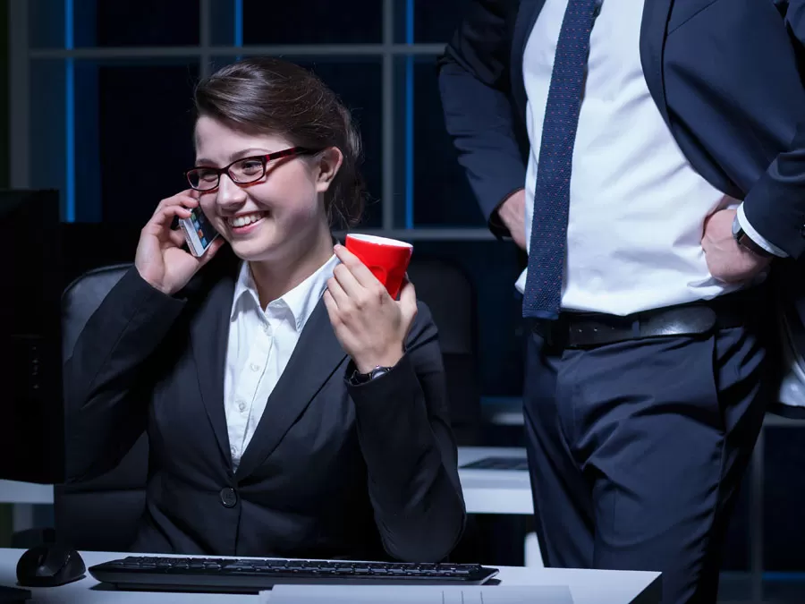 customer support agent in phone call holding red cup with boss hands on hips