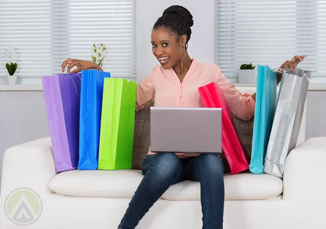 delighted woman excited sitting couch with shopping bags