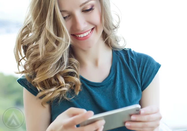 delighted woman reading smartphone