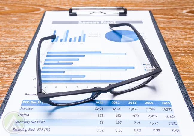 eye glasses on clipboard of document reports charts graphs
