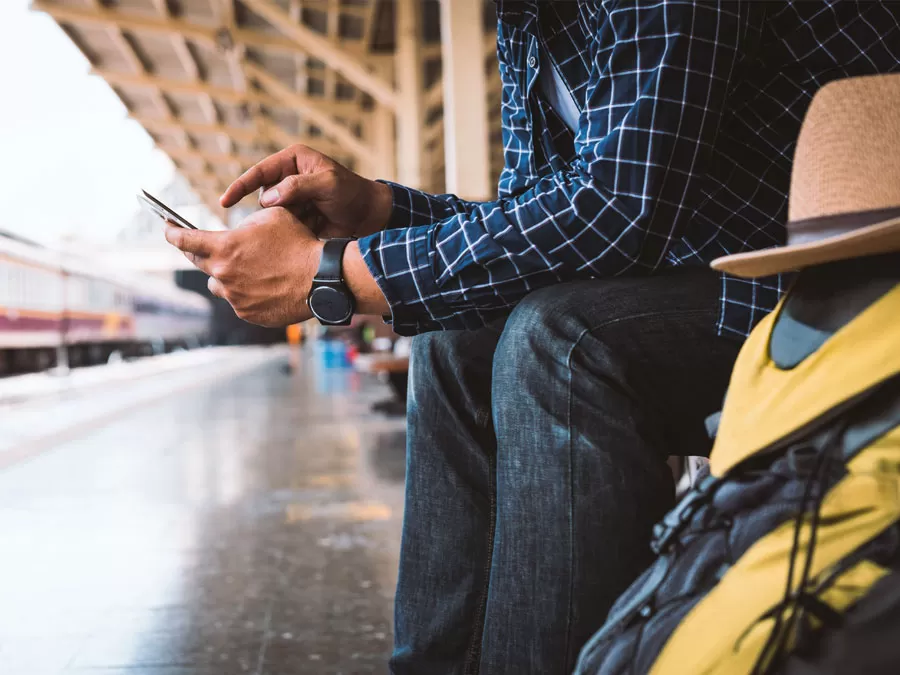 tourism hospitality need multilingual call center depiction tourist hand using smartphone next to travel bags in train station