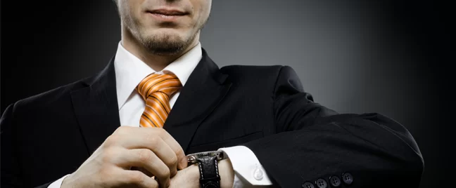 businessman holding up wristwatch