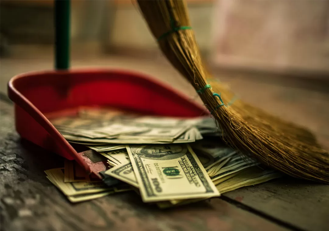 sweeping money into dustpan