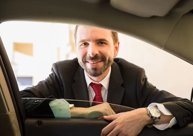 businessman smiling from outside car door