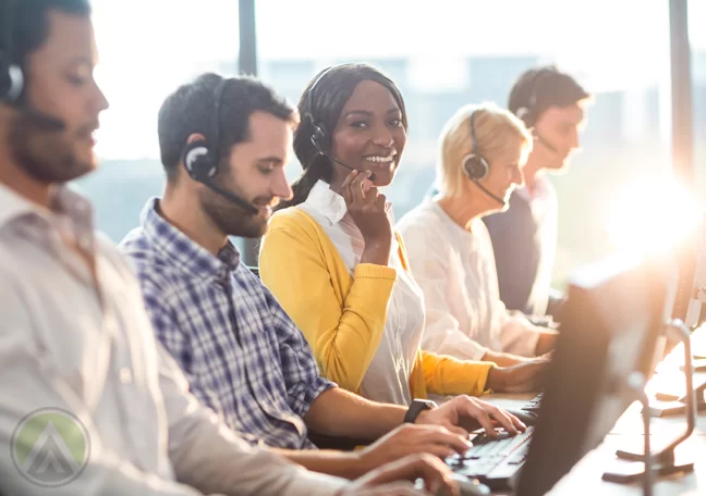 smiling call center agent surrounded by busy customer service coworkers