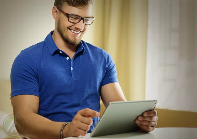 smiling man in glasses using tablet