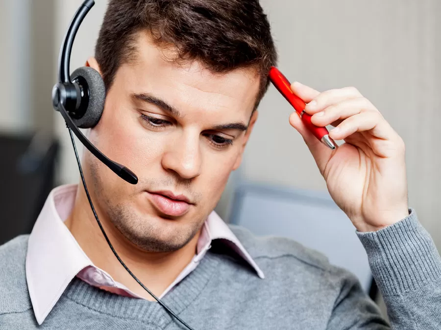 stressed confused call center agent holding pen looking at monitor