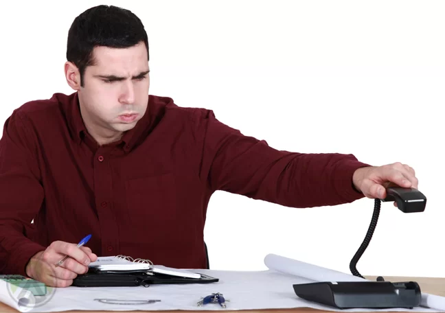 annoyed businessman hanging up landline phone