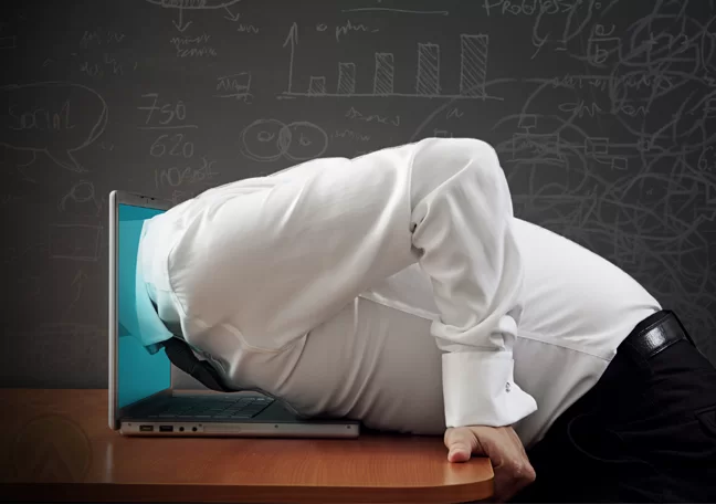 businessman head stuck in laptop screen