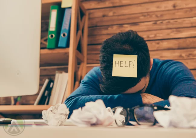 businessman tired face buried in crumpled paper