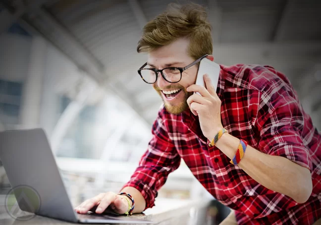 smiling man in glasses in phone call using laptop