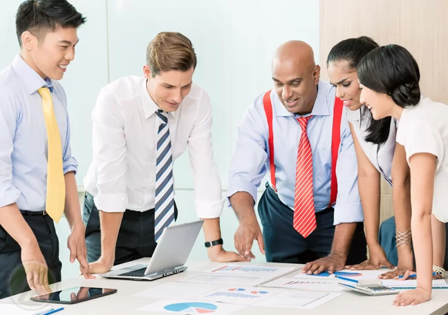 business development team in meeting looking at documents printed numbers