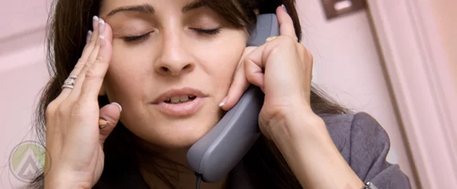 business woman with headache talking on phone