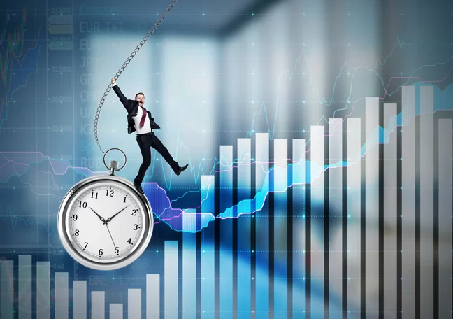 businessman dangling pocket watch over business report charts