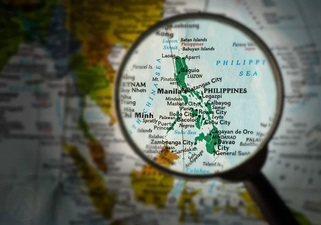 magnifying lens pointing to Philippines on map