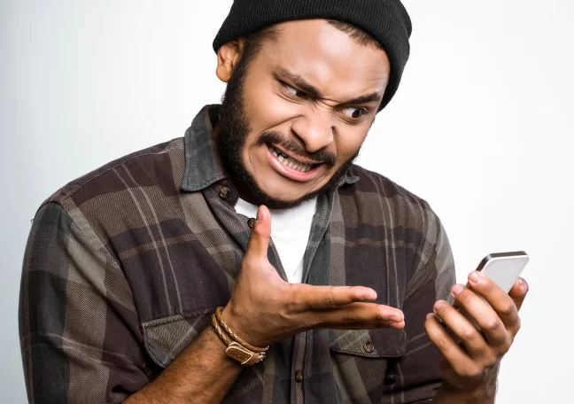 man annoyed at smartphone