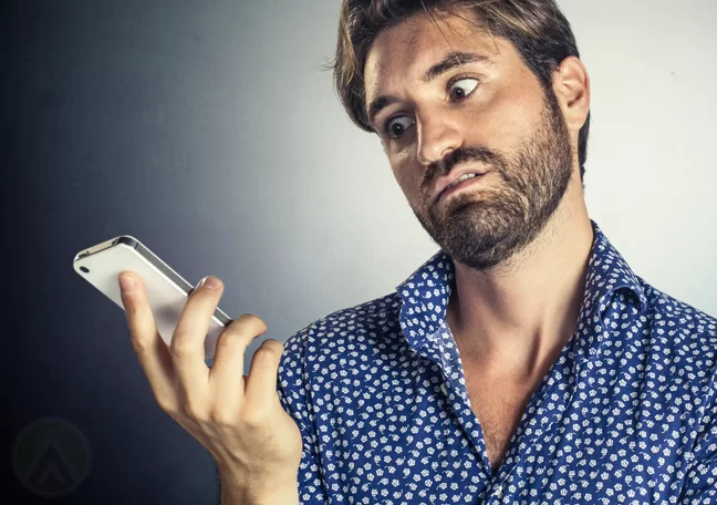 man in hawaiian blue shirt annoyed at phone