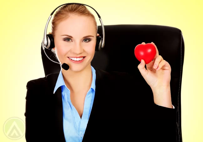 smiling blond call center agent holding rubber heart