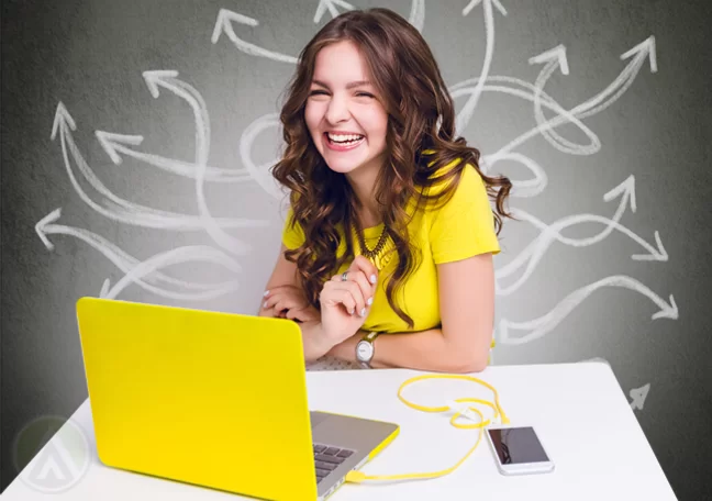 smiling woman in yellow using laptop