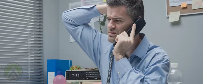 confused businessman scratching his head in office