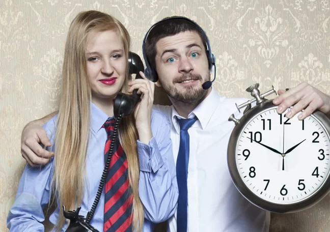 call center agent holding wall clock with customer using phone 