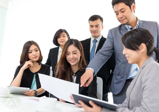 company boss team leader pointing to laptop screen to employees group