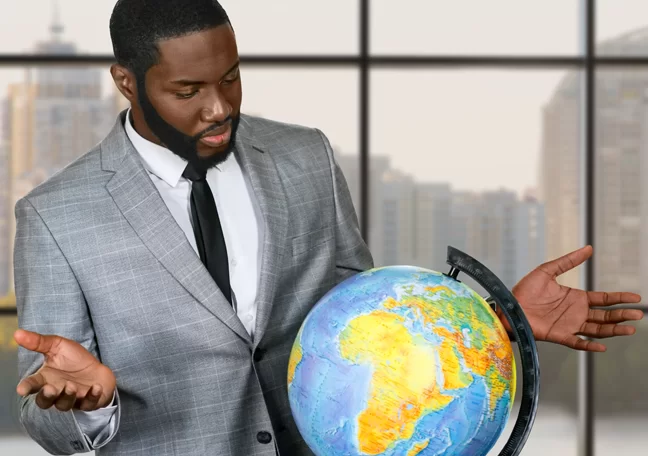 confused businessman looking at globe