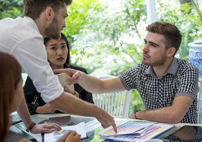 heated discussion in office meeting coworkers pointing fingers