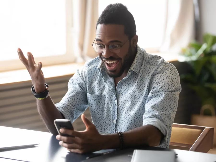 Excited man looking at smartphone