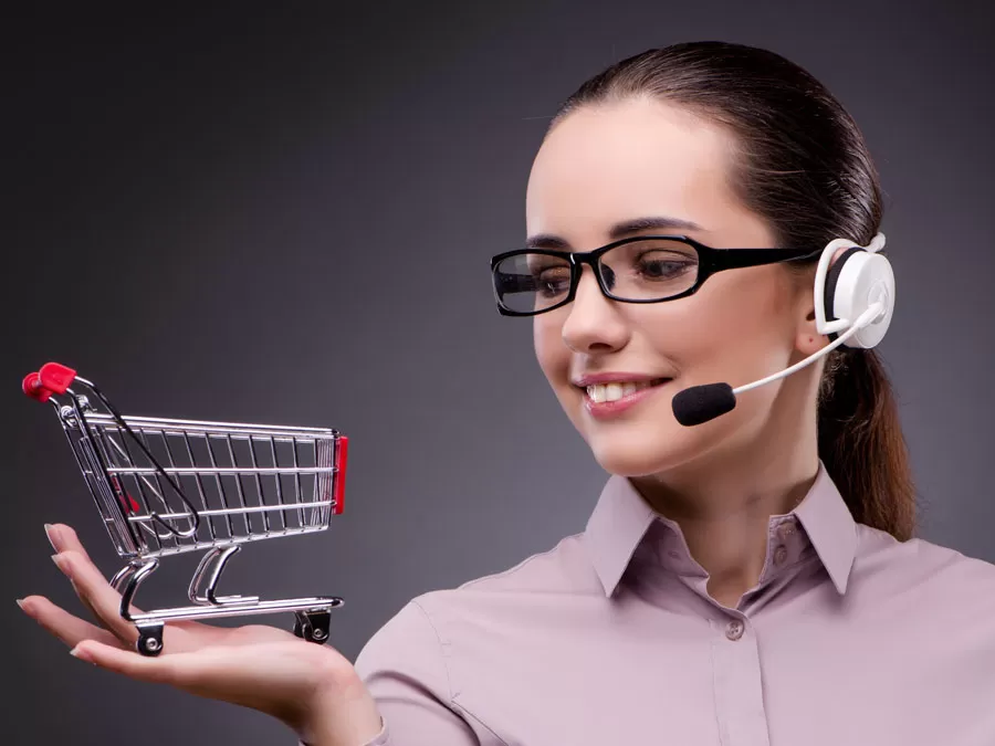 smart ecommerce call center agent holding miniature shopping cart
