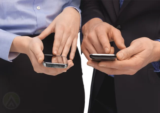 male female business executives using smartphone to read send sms text messages